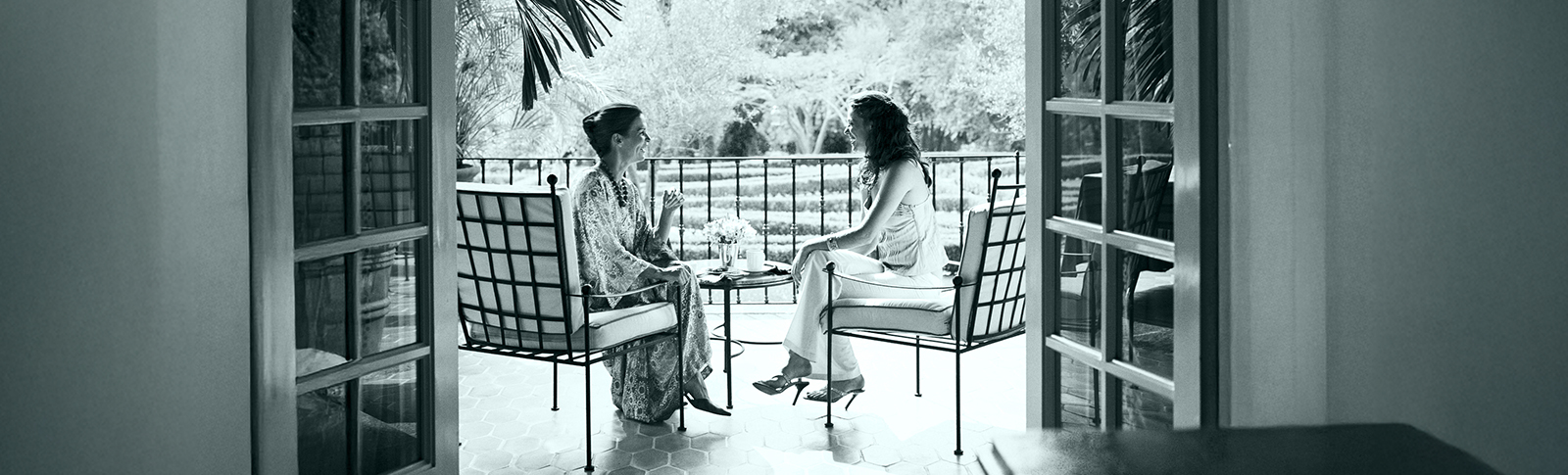 Due signore conversano su una terrazza.