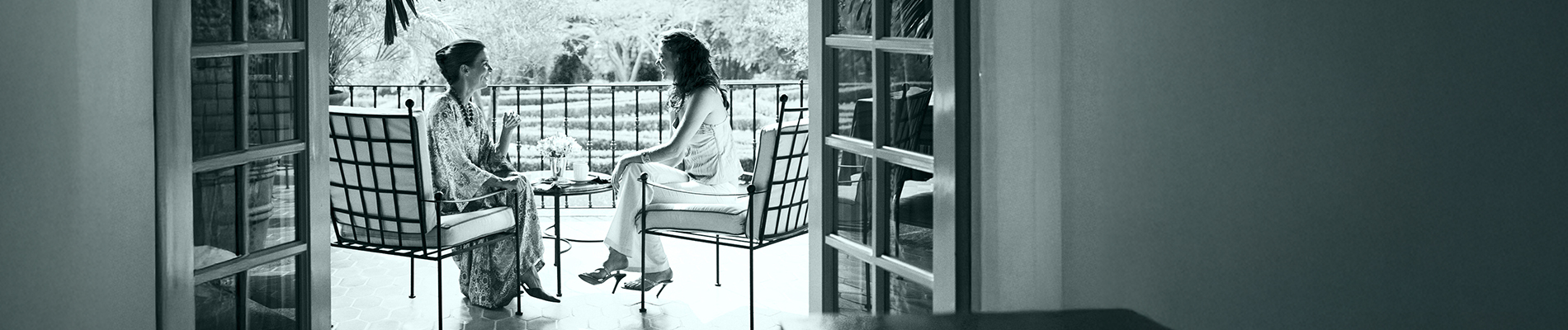 Due signore conversano su una terrazza.